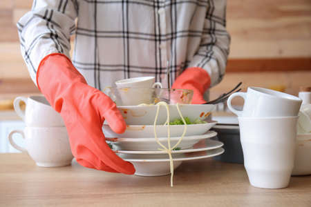 Woman with dirty dishes in kitchenの写真素材