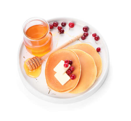 Tasty pancakes with honey, butter and berries on white backgroundの写真素材
