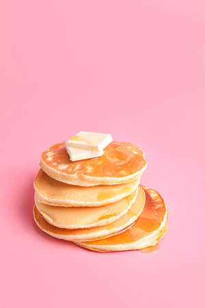 Tasty pancakes with honey and butter on color backgroundの写真素材
