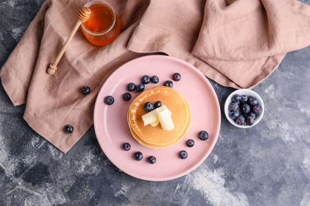 Tasty pancakes with butter and berries on gray backgroundの写真素材