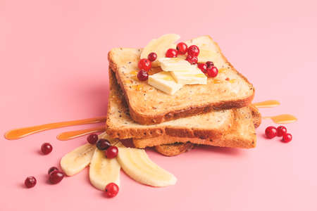 Tasty toasted bread with honey, butter and fruits on color background