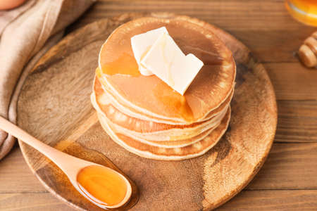 Tasty pancakes with honey and butter on plateの写真素材