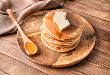 Tasty pancakes with honey and butter on plateの写真素材