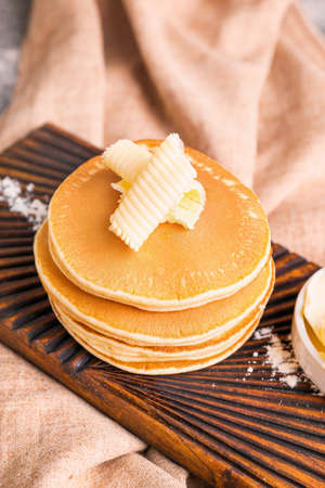 Tasty pancakes with butter on board
