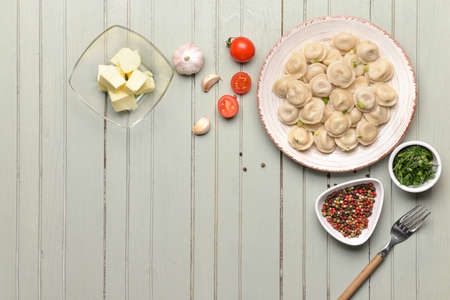 Plate with tasty dumplings, butter and spices on tableの写真素材