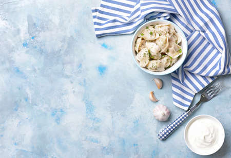 Bowl with tasty dumplings and sauce on color backgroundの写真素材