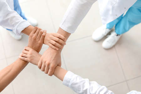 Group of doctors holding hands together in clinic, top view. Unity conceptの写真素材