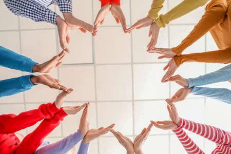 Group of people putting hands together indoors, bottom view. Unity conceptの写真素材