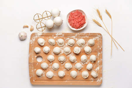 Preparing of tasty dumplings on white background