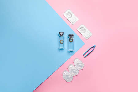 Containers with contact lenses and tweezers on color backgroundの写真素材