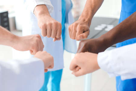 Group of doctors putting hands together in clinic. Unity conceptの写真素材