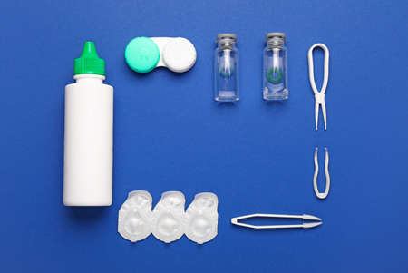 Frame made of containers with contact lenses, solution and tweezers on color backgroundの写真素材