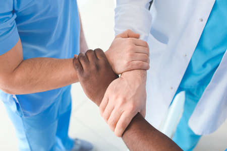 Group of doctors holding hands together in clinic. Unity conceptの写真素材