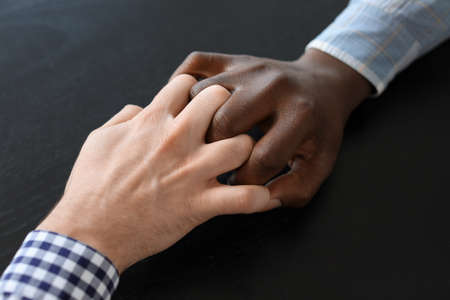 People holding hands together on dark background. Unity conceptの写真素材