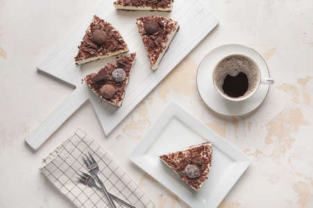 Pieces of tasty chocolate cheesecake and cup of coffee on white backgroundの写真素材