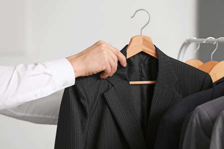 Young male stylist near rack with clothes, closeupの写真素材