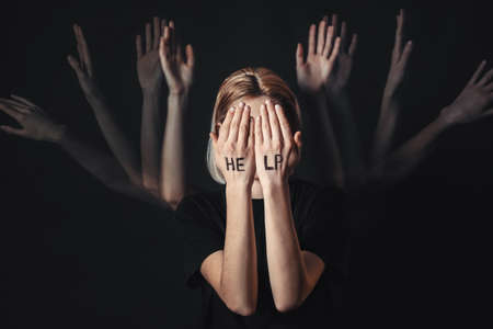 Depressed young woman on dark backgroundの写真素材