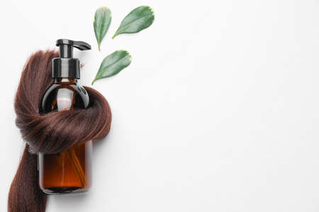 Hair strand and shampoo with herbal extract on white backgroundの写真素材