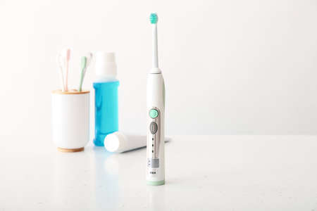 Electric tooth brush and set for oral hygiene on table