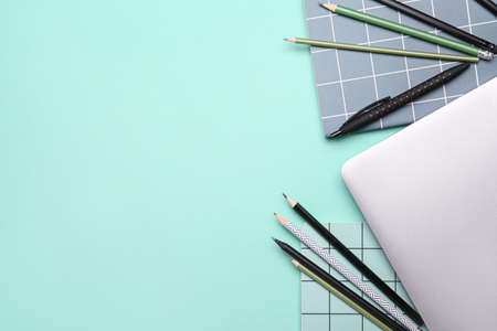 School supplies with laptop on color background