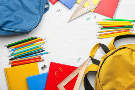 Frame made of school supplies on white wooden background