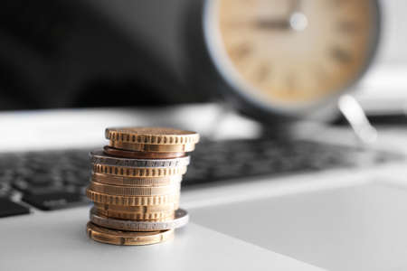 Coins on laptop, closeup. Time management conceptの写真素材