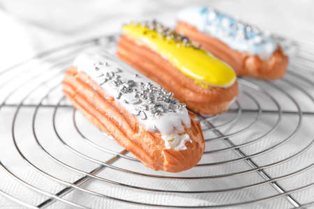 Tasty eclairs on cooling rack