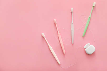 Tooth brushes and floss on color backgroundの写真素材