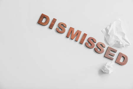 Word DISMISSED with crumpled paper on white backgroundの写真素材