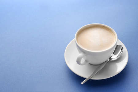 Cup of tasty cappuccino on color background