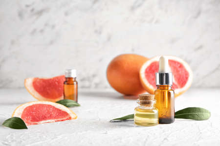 Bottles of grapefruit essential oil on tableの写真素材