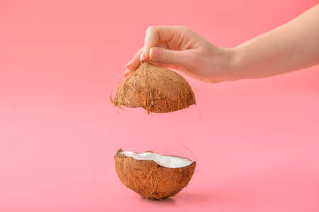Female hand with tasty coconut on color backgroundの写真素材