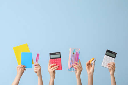 Many hands with school supplies on color backgroundの写真素材