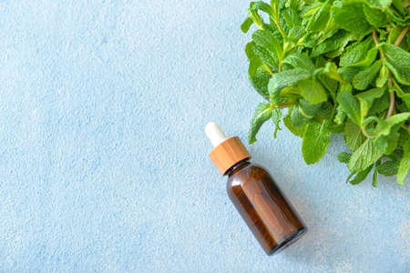 Bottle of mint essential oil on tableの写真素材