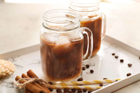 Mason jars of tasty cold coffee on trayの写真素材