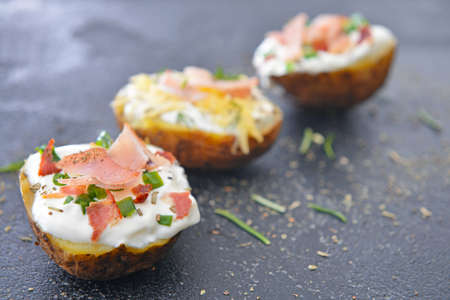 Tasty baked potato with sour cream on dark backgroundの写真素材