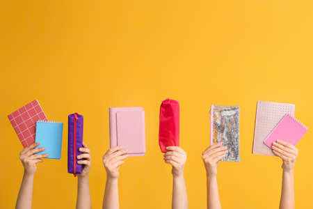 Many hands with school supplies on color backgroundの写真素材