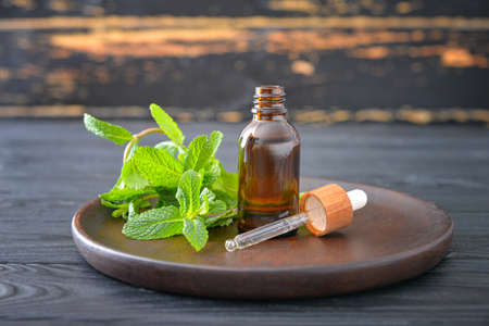 Bottle of mint essential oil on tableの写真素材
