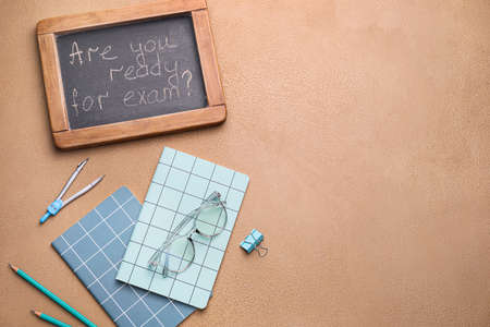 Stationery and chalkboard with text ARE YOU READY FOR EXAM? on color backgroundの写真素材