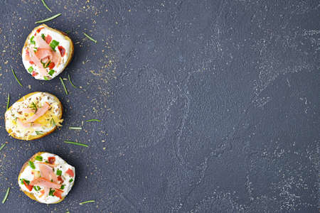 Tasty baked potato with sour cream on dark backgroundの写真素材