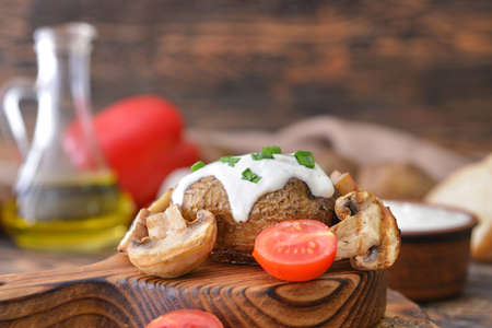 Tasty baked potato with sour cream and mushrooms on tableの写真素材