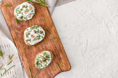 Tasty baked potato with sour cream and mushrooms on white backgroundの写真素材