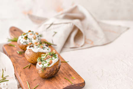 Tasty baked potato with sour cream and mushrooms on white backgroundの写真素材