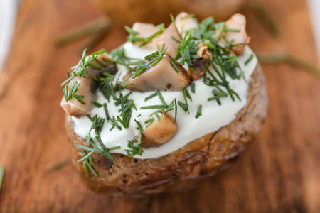 Tasty baked potato with sour cream and mushrooms on board, closeupの写真素材