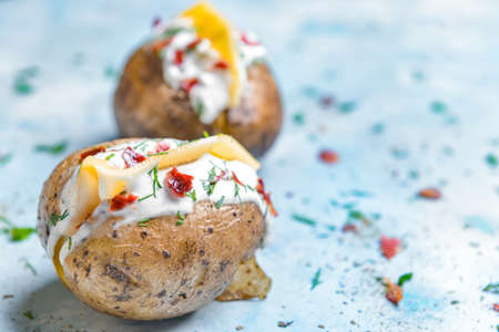 Tasty baked potato with sour cream on color backgroundの写真素材