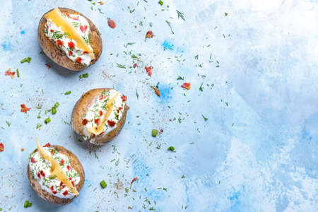 Tasty baked potato with sour cream on color backgroundの写真素材