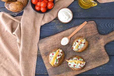 Tasty baked potato with sour cream on tableの写真素材