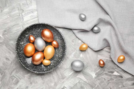 Plate with beautiful Easter eggs on tableの写真素材