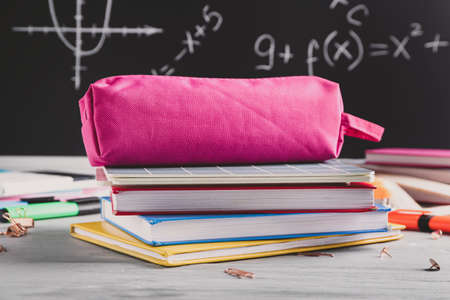 Pencil bag with stationery on desk in classroomの写真素材