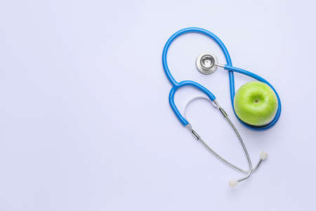 Fresh apple and stethoscope on white backgroundの写真素材